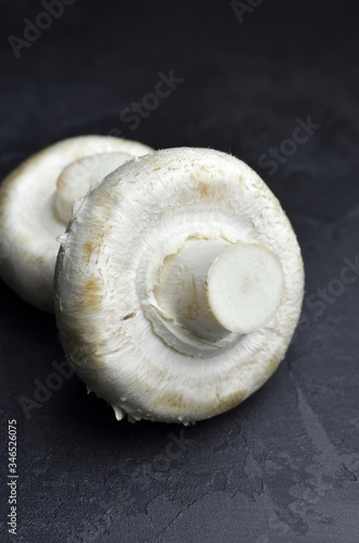 Fresh champignon mushrooms on dark background, ready for cooking.