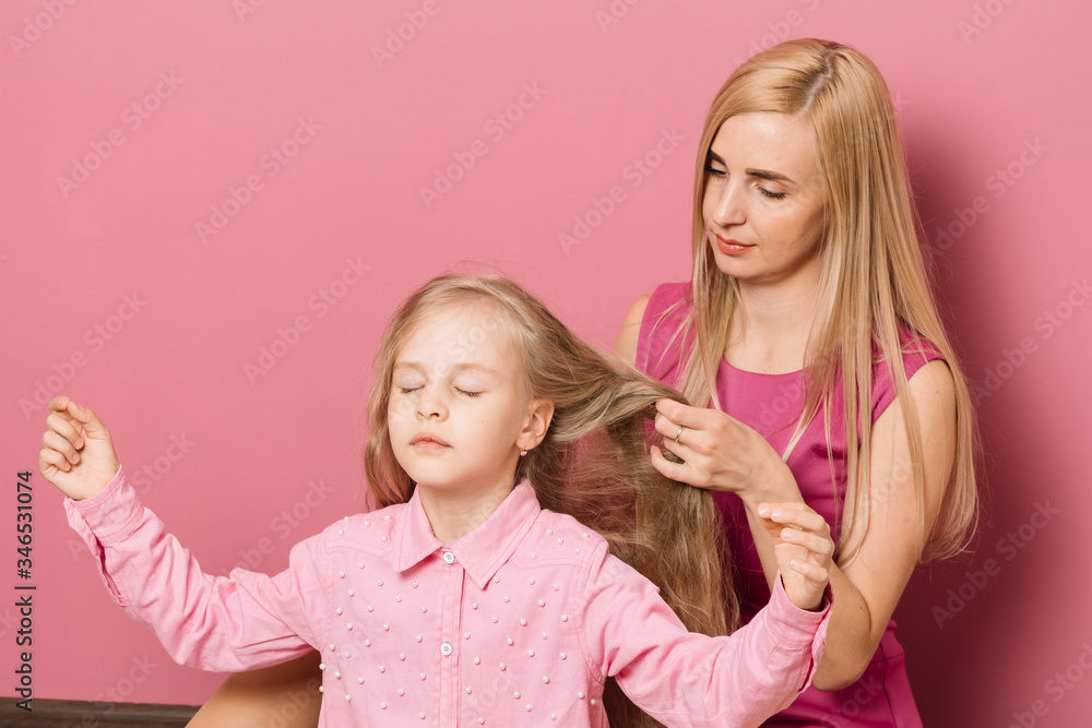 mother with daughter in pink clothes on a pink background mother with daughter in pink clothes on a pink background