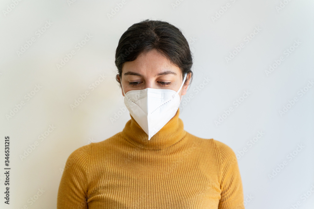 Portrait of young woman with respiratory problems wearing a preventive face mask at home. Health and clinic care for young high risk patients with coronavirus. Covid 19 quarantine at home concept. Portrait of young woman with respiratory problems wearing a preventive face mask at home. Health and clinic care for young high risk patients with coronavirus. Covid 19 quarantine at home concept.