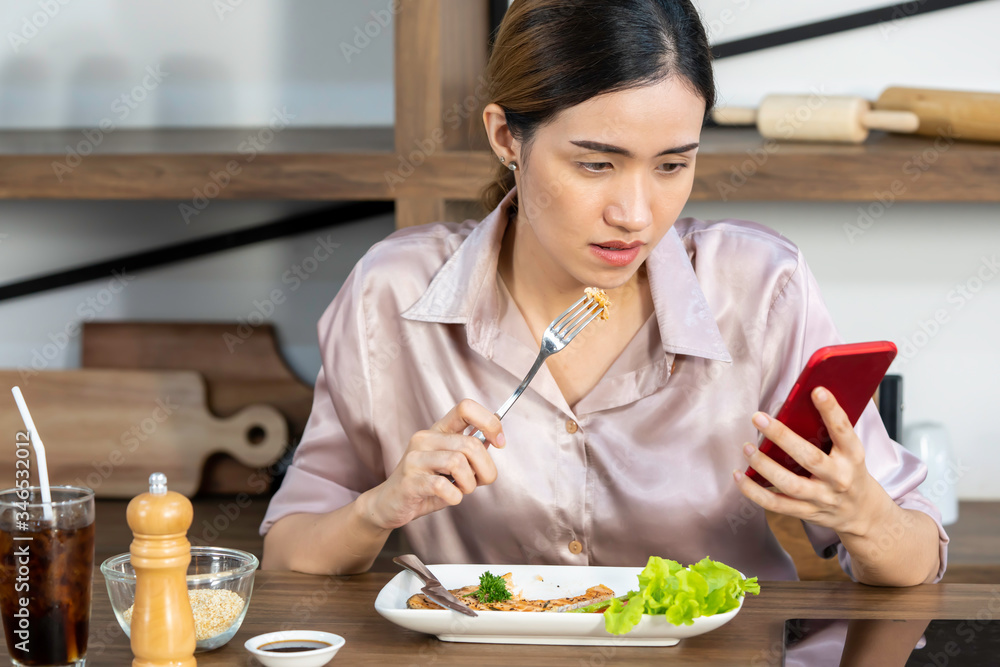 Women are watching or searching for coronavirus news on mobile phones while eating.