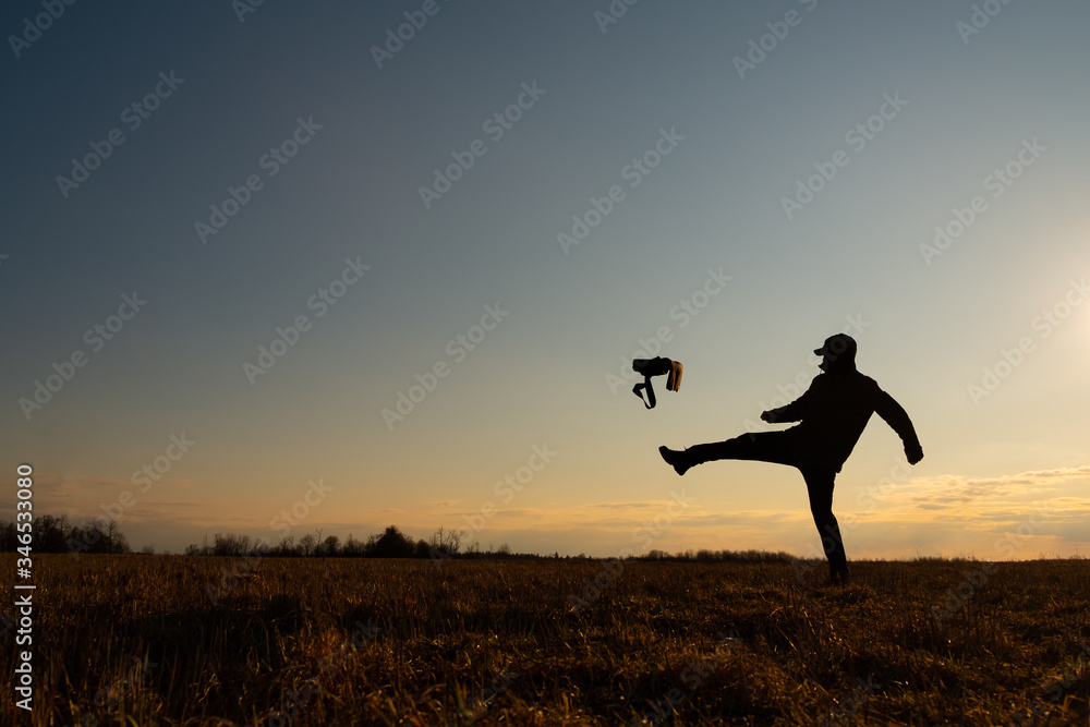 The contour of a man against the sky. The man kicks the bag. Problem Solving Concept