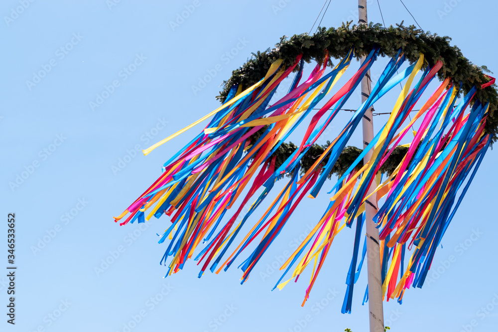 colourful maypole blowing in the wind with a blue sky background  - obrazy, fototapety, plakaty 