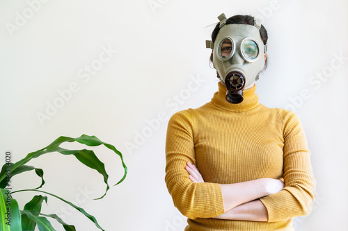 Horizontal view of woman with gas mask surrounded with plants at home isolated on white background. Conceptual idea of greenhouse effect in ecosystem. Quarantine at home covid 19 coronavirus concept.