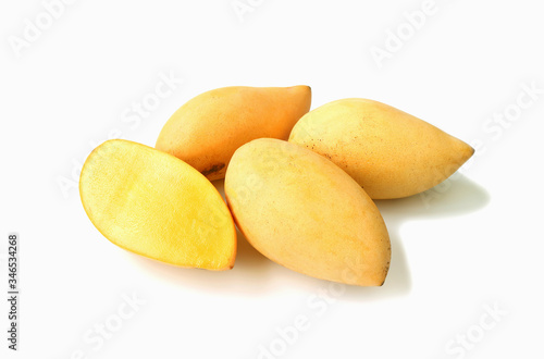 Fresh Ripe Thai Mango Cut in Half with Heap of Whole Fruit Isolated on White Background 