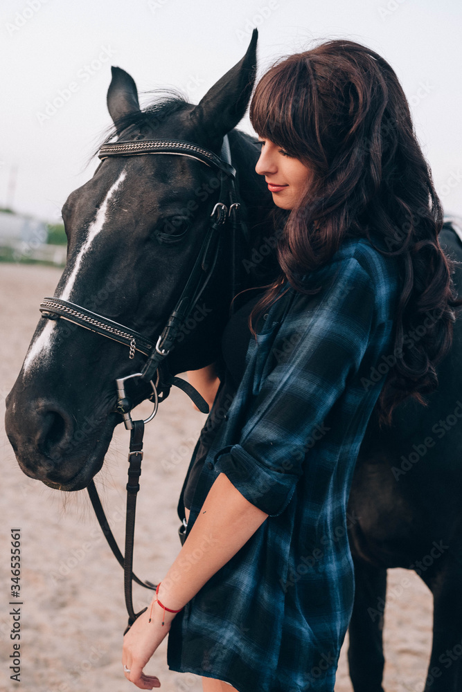 Obraz premium beautiful stylish fashion woman near horse on ranch. Fashion girl hugging a horse.