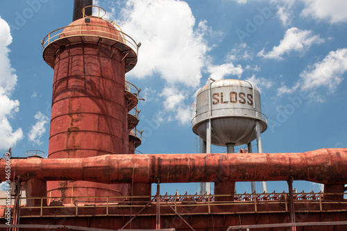 Sloss Furnaces National Historic Landmark, Birmingham Alabama USA, wide view of furnace and water tower against a brilliant blue sky with white clouds, horizontal aspect