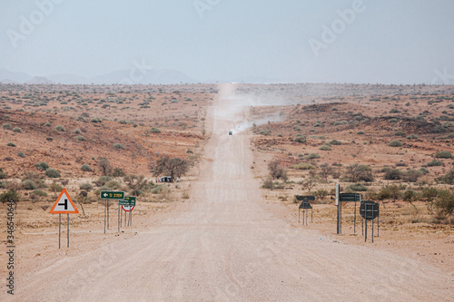 Cars kick up dust on the C35 gravel road in Tsiseb region, Namibia, Africa