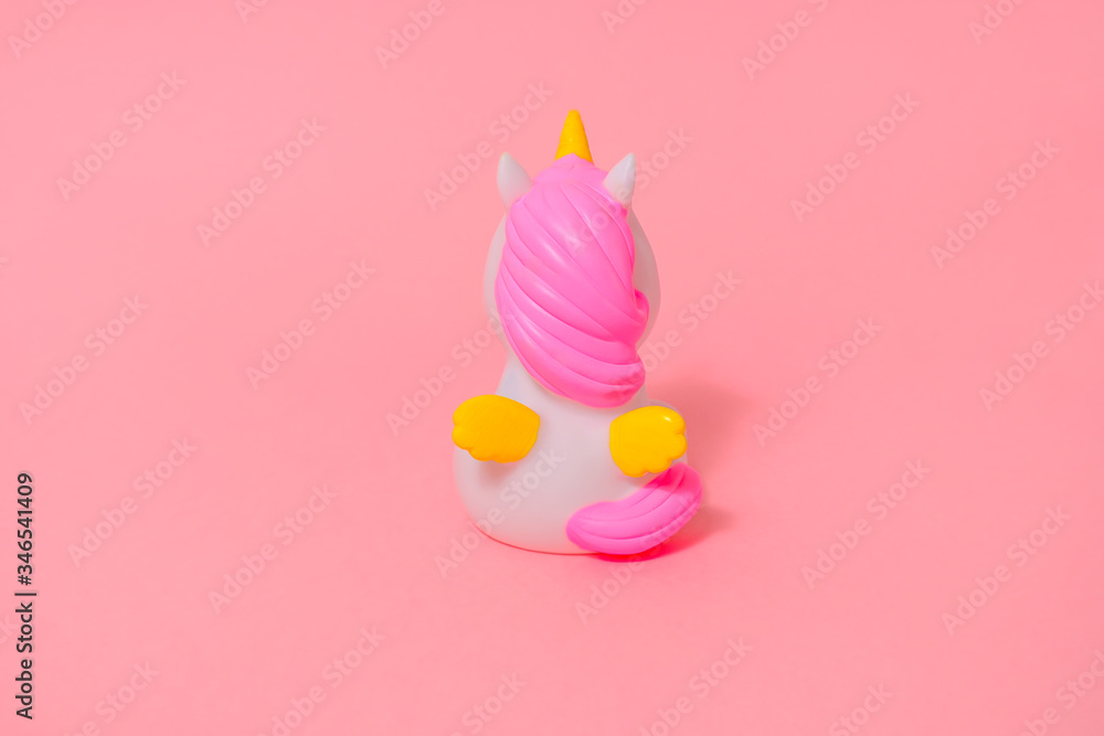 figurine of a white unicorn with a pink mane and yellow wings
