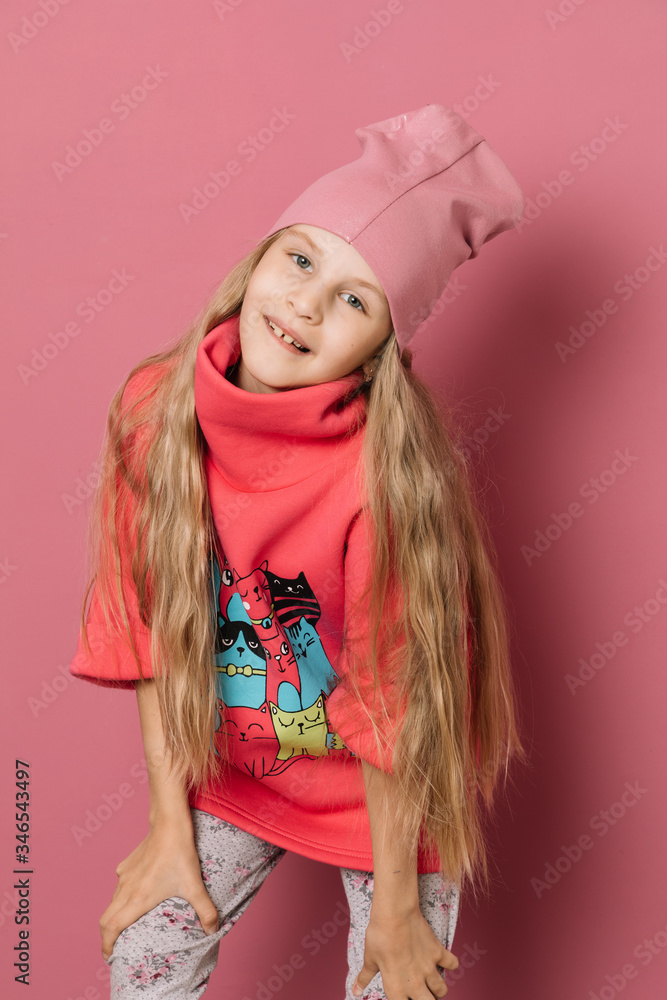 Little girl in pink clothes on a pink background