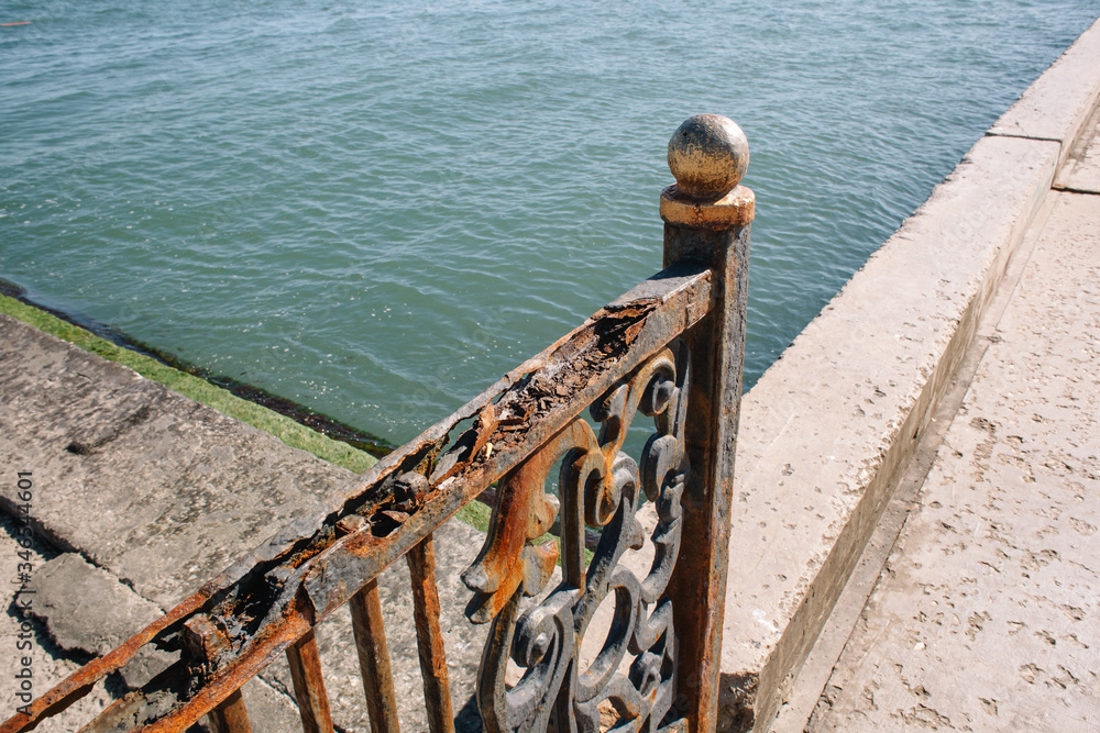 Rusty railings on the Black Sea coast. Iron construction gnawed iron cancer. Beautiful colorful collage.
