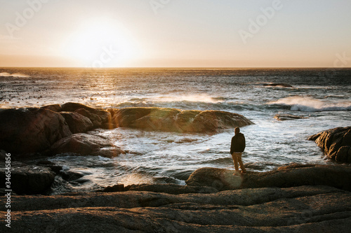 Adult male looking off into the distant ocean at sunset
