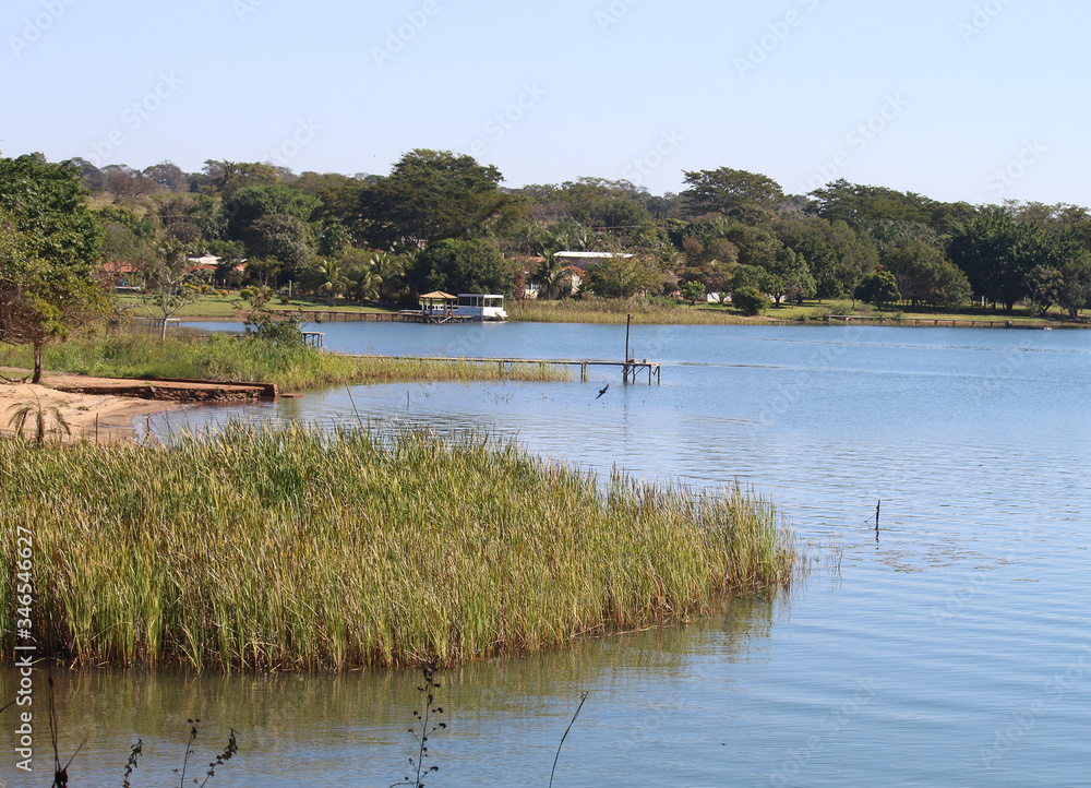 Grande lago azul, com vegetação e residências na margem Grande lago azul, com vegetação e residências na margem