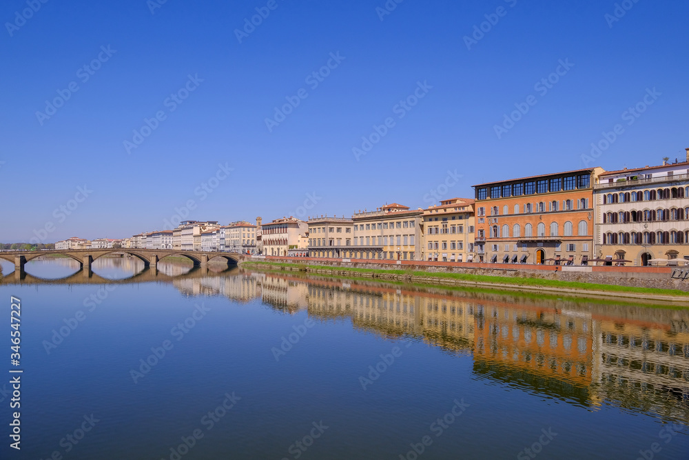 The famous Ponte Vecchio, the Old Bridge and city houses with reflections in the Arno River, Florence, Tuscany, Italy