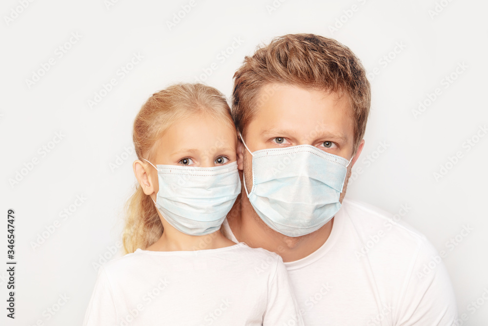 Family father and daughter in medical masks together on an isolated background