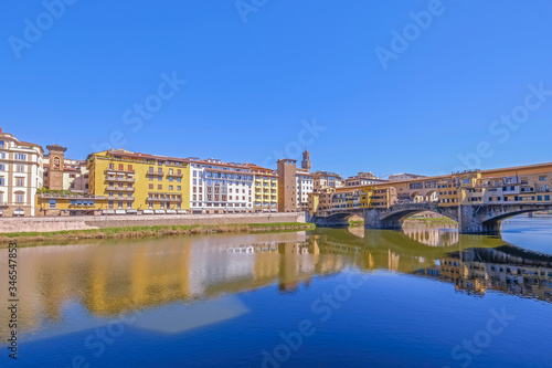 The famous Ponte Vecchio  the Old Bridge and city houses with reflections in the Arno River  Florence  Tuscany  Italy