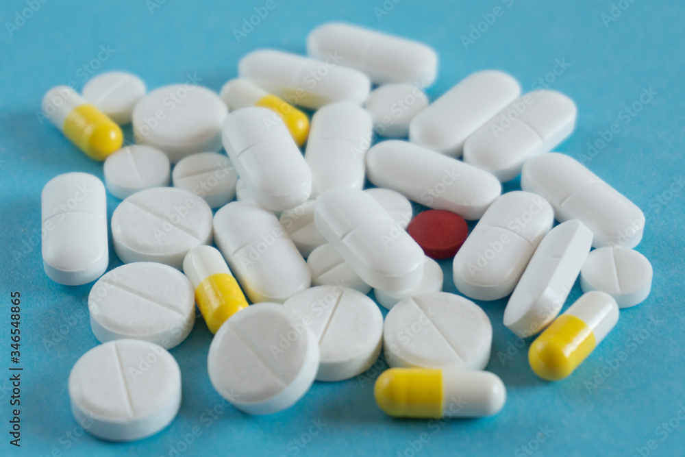 pile of pills on blue background with copy space. medicine concept