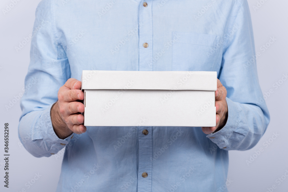 Male hands holding a cardboard box. Front view. Express delivery. Postman brought parcel Male hands holding a cardboard box. Front view. Express delivery. Postman brought parcel