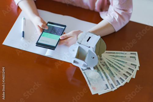 Japanese woman counting cash for saving money photo