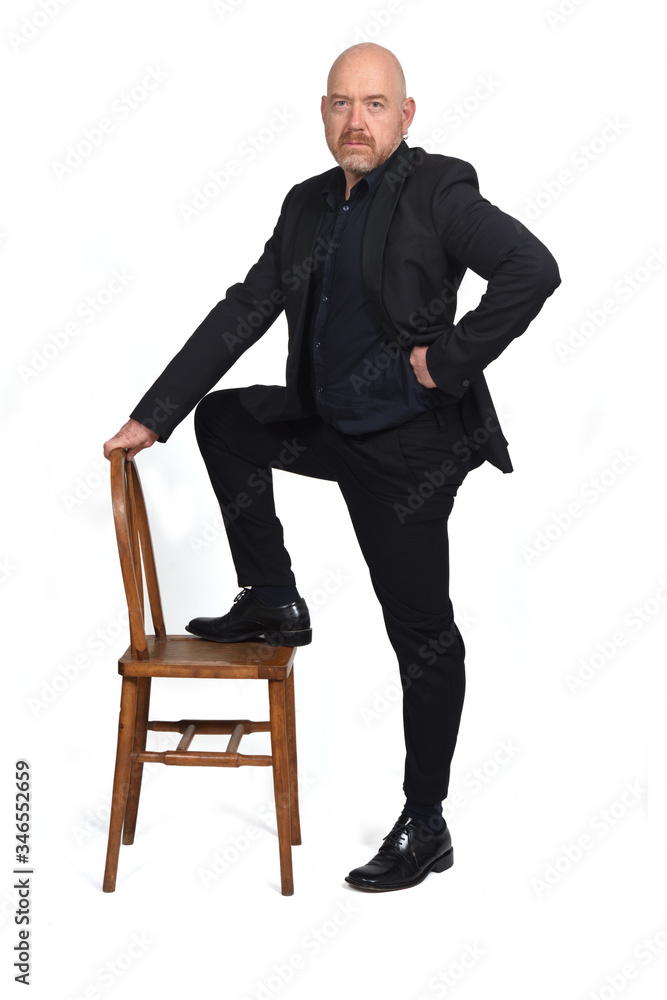man in suit playing with a chair on white background man in suit playing with a chair on white background