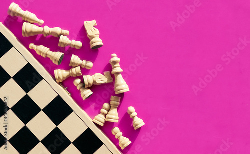 Obraz na plátně White chess pieces lying next to a chessboard, top view.