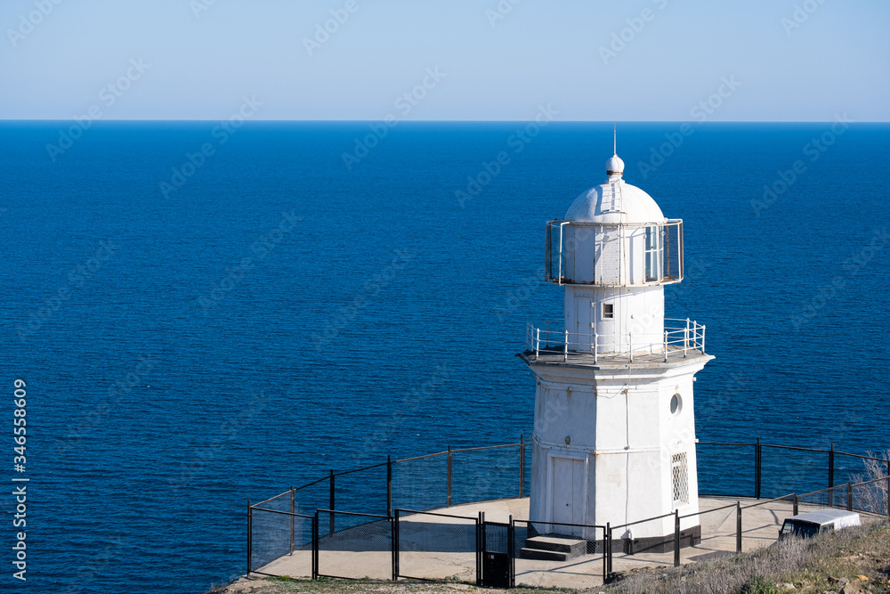 White Lighthouse against the blue sea. 