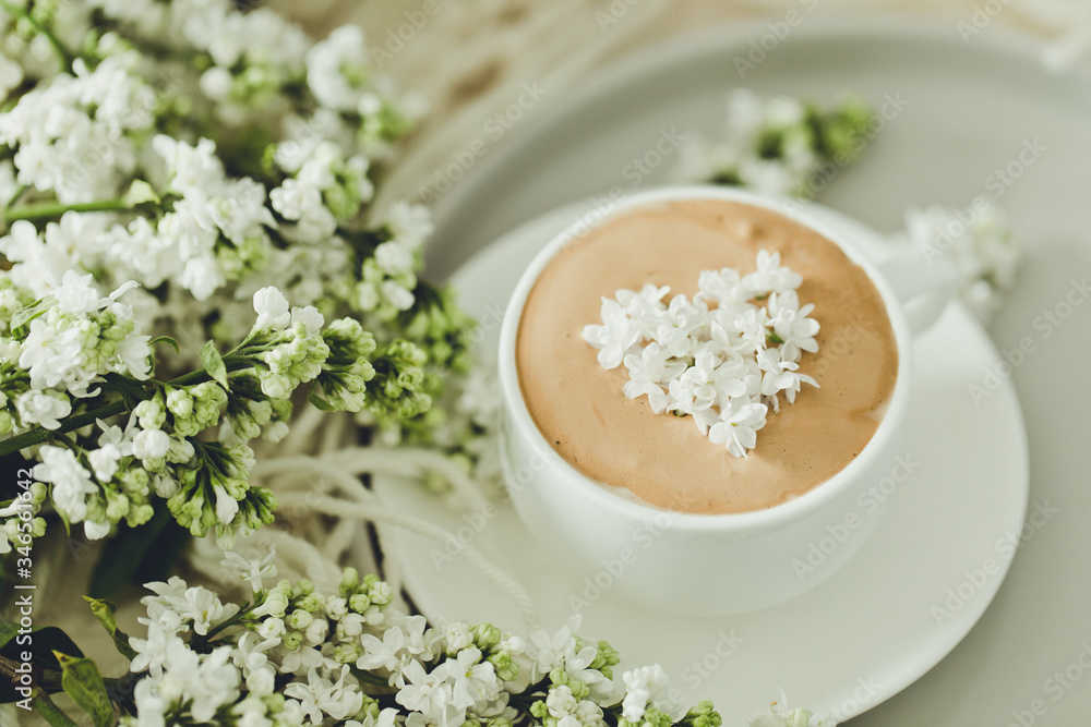 Composition with the branches of lilac and fresh coffee with foam in white cup. Relax time, pay yourself first/ Composition with the branches of lilac and fresh coffee with foam in white cup. Relax time, pay yourself first/