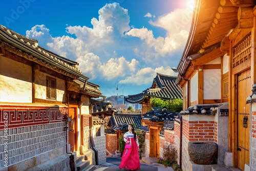 Beautiful girl wearing Korean traditional hanbok at Bukchon Hanok Village. Traditional Korean style architecture in Seoul,Korea. photo