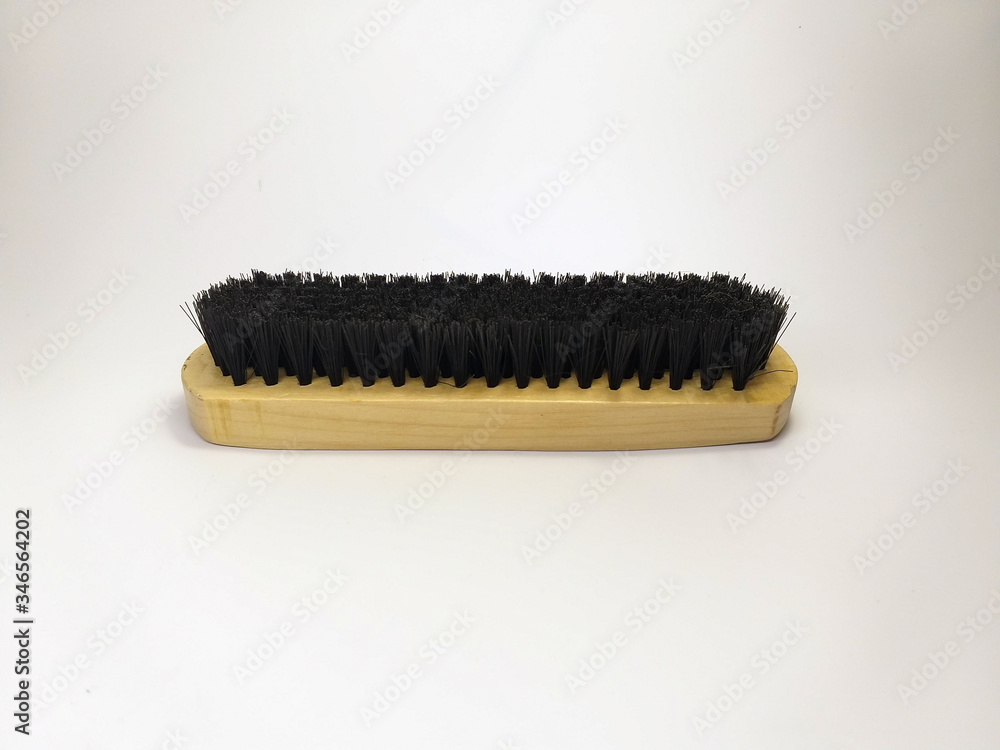 Wooden brush for cleaning clothes and shoes on a white background. Wooden brush for cleaning clothes and shoes on a white background.