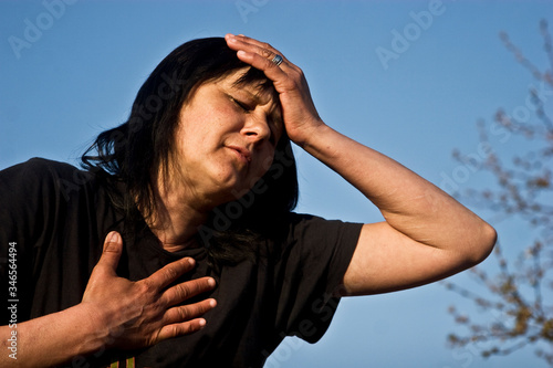Woman holding her head. A young girl is having a headache. Symptoms A woman suffers a headache. Chest pain. Woman experiencing shortness of breath