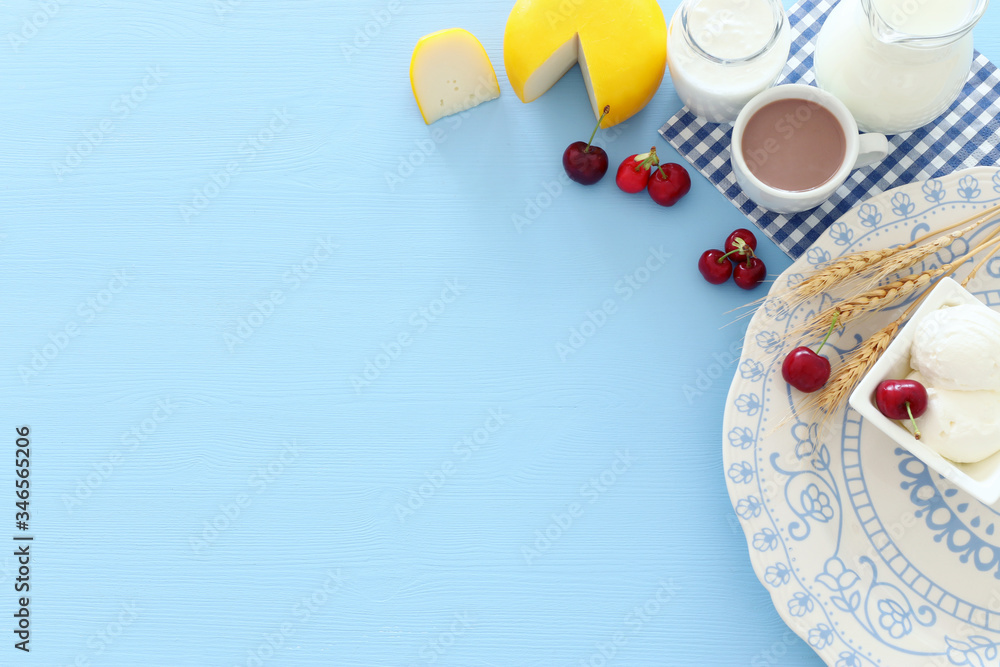 Top view photo of dairy products over pastel blue background. Symbols of jewish holiday - Shavuot