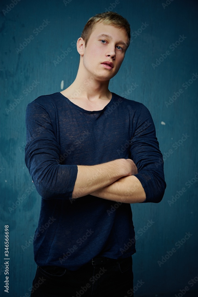 Handsome young man in stylish clothes posing against studio background. portrait of a young man with blond hair and blue eyes.
