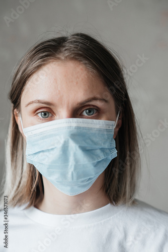 .young girl with short hair in a white t-shirt in a mask  at home  close-up. Coronavirus. Quarantine