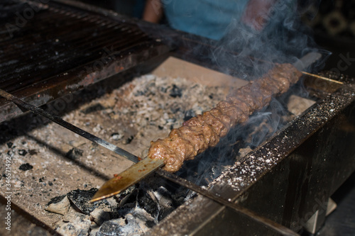 Chef preparing meat on the grill, during outdoor outside food festival