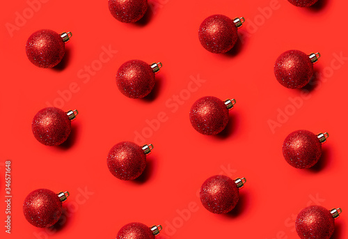 Fototapeta Naklejka Na Ścianę i Meble -  pattern christmas tree red shiny toys on a red background from above