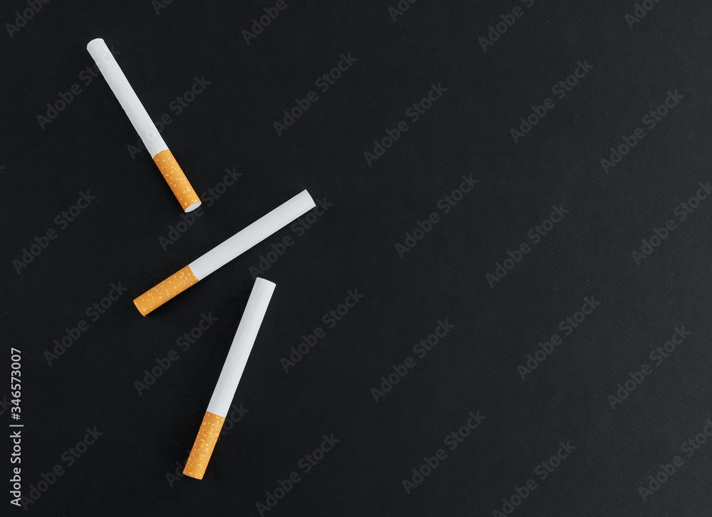 Three cigarettes on a black background. View svrhu and place for text. Three cigarettes on a black background. View svrhu and place for text.