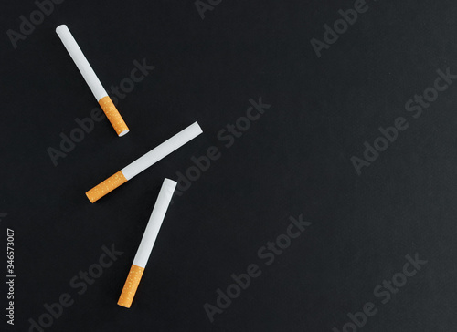 Three cigarettes on a black background. View svrhu and place for text.