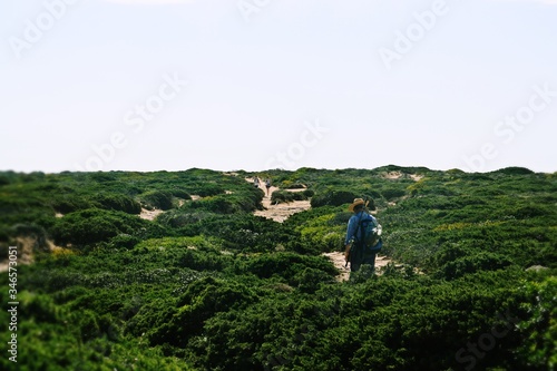 Anciano recorriendo un sendero para llegar al acantilado donde pescar. Cabo San Vicente, Algarve, Portugal.