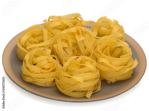 Italy dry raw pasta tagliattele on the plate. Closeup on white background