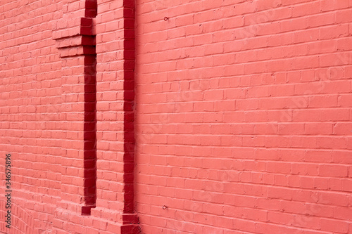 Old red painted brick wall texture background with decorative vertical brick column moulding  showing weathering from normal aging