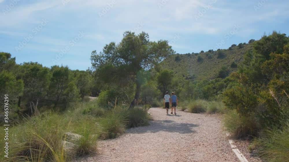 Two children walking in natural park, green forest and enjoying the beautiful sunnny day Two children walking in natural park, green forest and enjoying the beautiful sunnny day