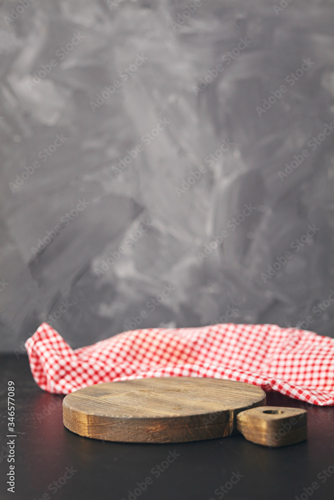 Red napkin at empty cutting board on gray background. Copy space