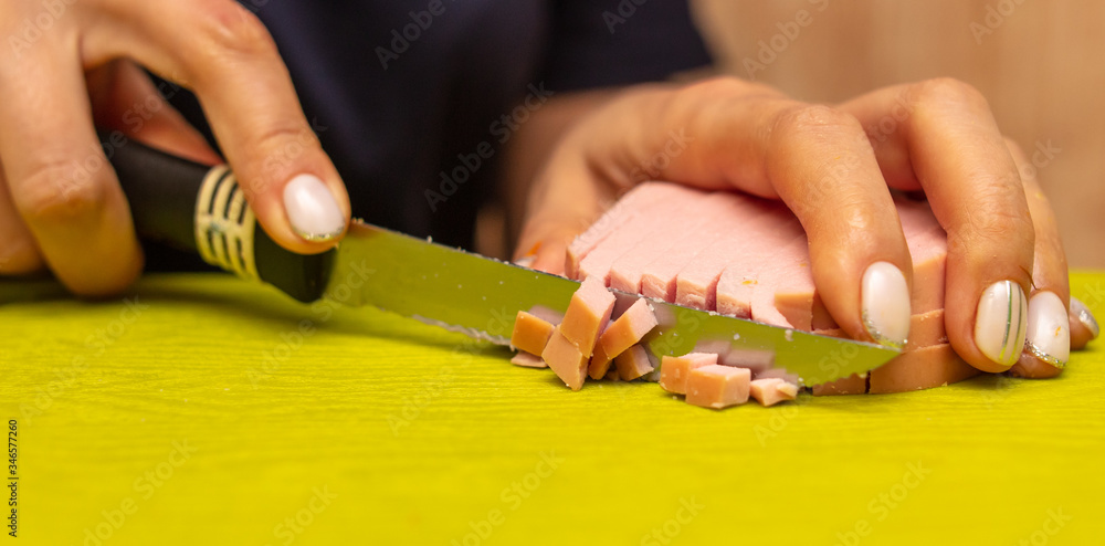 The girl cuts the sausage with a knife The girl cuts the sausage with a knife