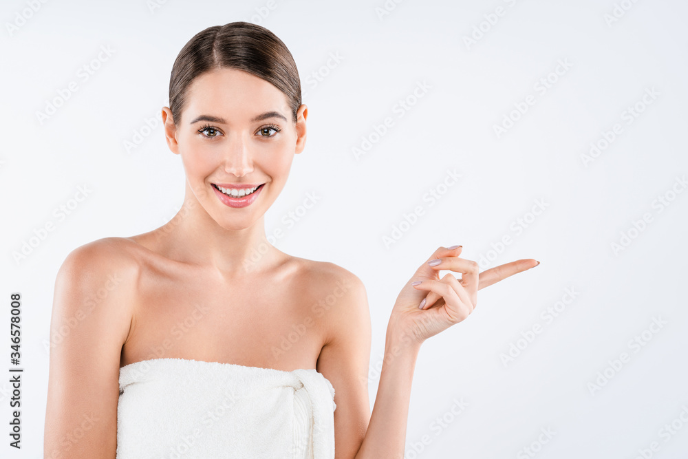 Young beautiful woman wearing towel after shower over isolated white background smiling and looking at the camera and pointing Young beautiful woman wearing towel after shower over isolated white background smiling and looking at the camera and pointing