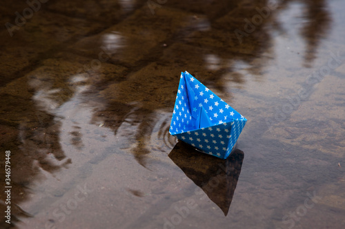 
colored paper ship floats in water