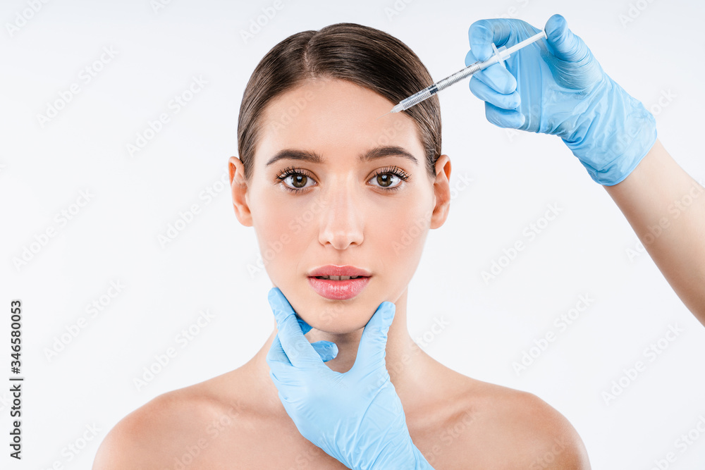 Plastic surgery clinic.Beautiful woman gets injection in her face.