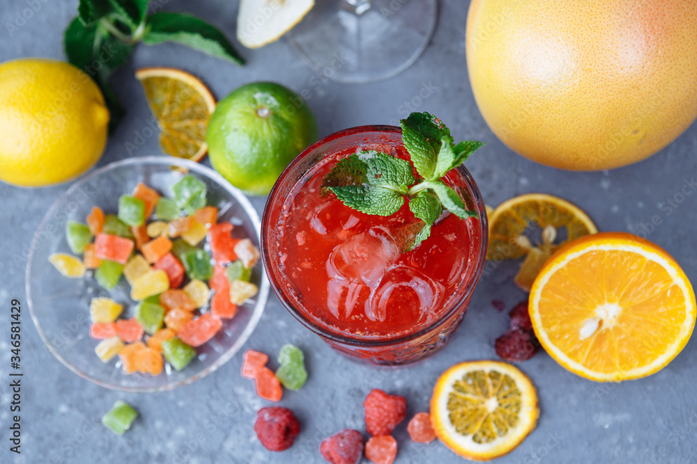 Fresh pink lemonade with raspberries decorated with mint leaves, orange, lime and candied fruit on a decorative background Fresh pink lemonade with raspberries decorated with mint leaves, orange, lime and candied fruit on a decorative background