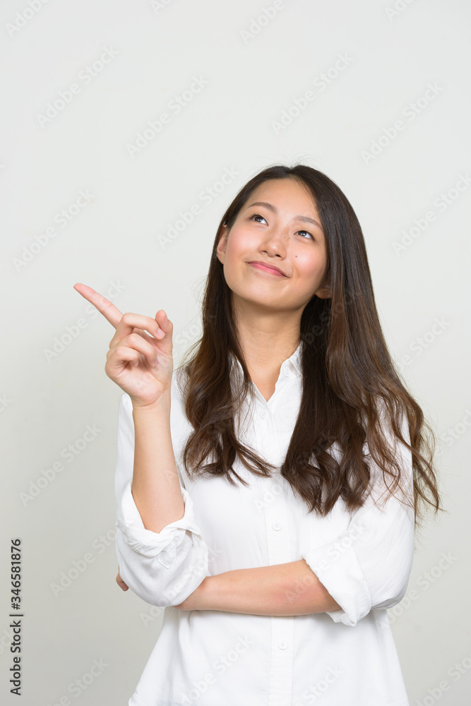 Portrait of young beautiful Asian businesswoman thinking Portrait of young beautiful Asian businesswoman thinking