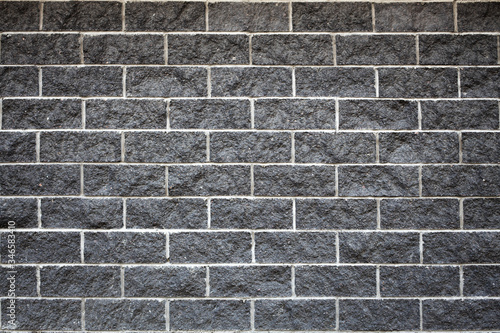 horizontal abstract black brick wall, natural stone texture, white cement between bricks, black brickwall for design