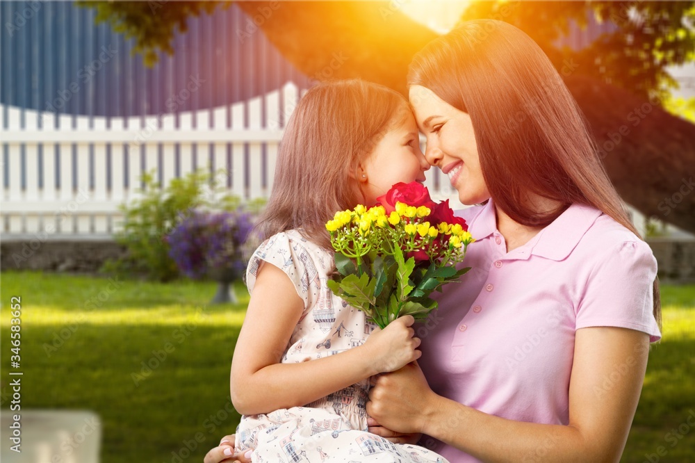 Mother and daughter with a bouquet of flowers on the outdoor background. Mother and daughter with a bouquet of flowers on the outdoor background.
