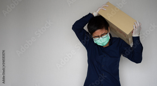 Delivery man employee wearing face mask gloves carrying package paper box. Service quarantine pandemic coronavirus virus 2019-ncov concept
 photo